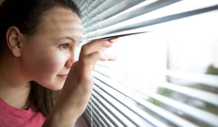 lady peeking out blinds to see buyers